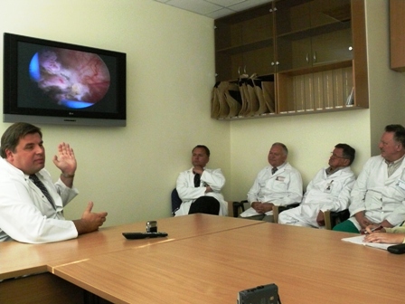 Gydytojas Algimantas Sruogis ir operaciją ekrane stebintys jo kolegos