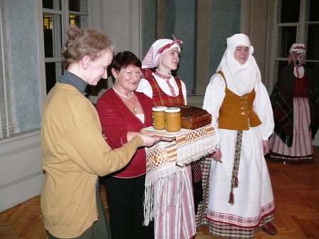 Projekto vadovė Ramutė Raciūtė ir galerijos „Židinys“ vedėja Laimutė Lukoševičienė darbščiąsias audėjėles apdovanojo lietuviška juoda rugine duona ir medumi