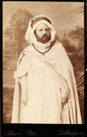 Jurgis Zauerveinas, mėgęs fotografuotis įvairių tautų egzotiška apranga, šioje nuotraukoje – Alžyro čiabuvio drabužiais. 1884 m. Jeano Geiserio nuotrauka, dauginimo tikslu reprodukuota Bernhardo Petri Getingene